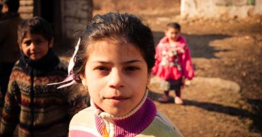 serednie-ukraine-march-09-2011-portrat-of-romani-schoolgirl-looking-at-the-camera-younger-siblings_t20_JJYomO